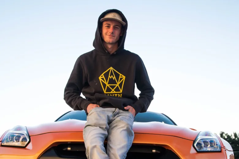 Andrew Lee standing beside his car